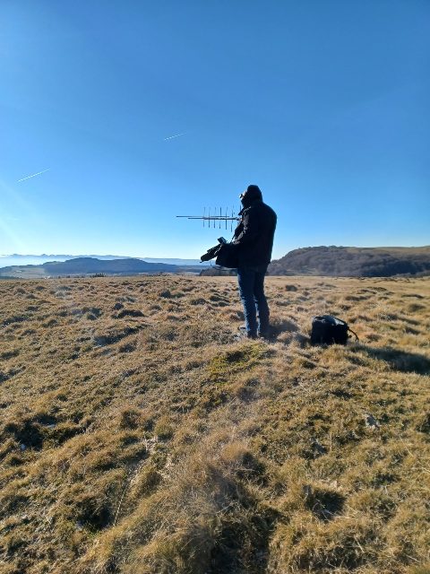 On a grassy plateau, the Yagi in hand, with the mountains in the distance — December 2025