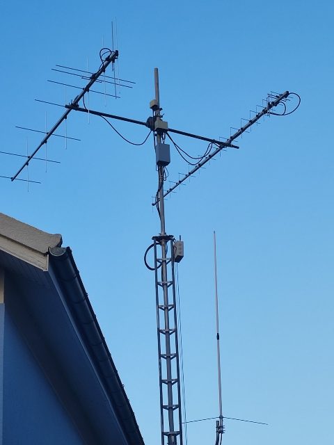 The top of the tower in April 2025: the VHF and UHF crossed Yagis, the boxes under the cross-boom, the collinear beside them